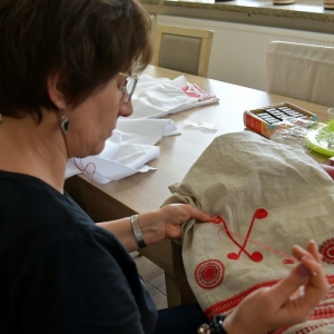 Na zdjęciu uczestniczka projektu Haft Kurpi Białych wyszywa wzory kurpiowskie