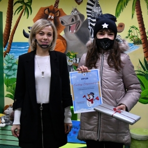 Na zdjęciu Dyrektor Biblioteki p. Ewa Młynarczuk oraz uczestniczka ferii odbierajaca nagrodę za wykonany pamiętnik 