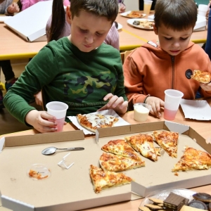 Dzieci posilają się pizzą 
