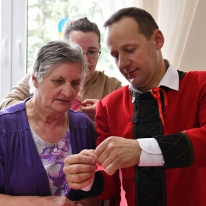 Pan Stanisław Ropiak udziela rad uczestnikom, jak wykonać kwiaty z bibuły